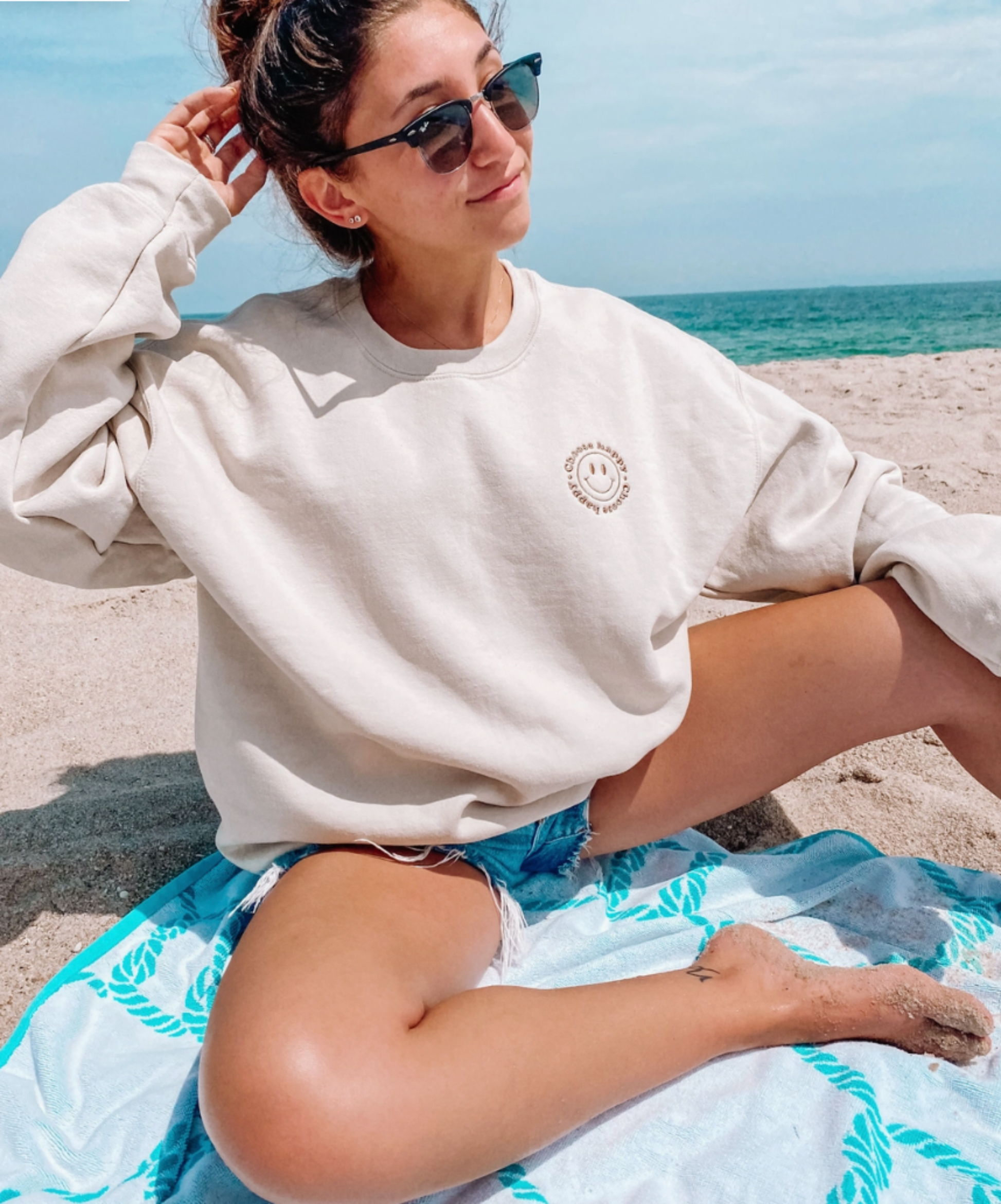 girl on beach with embroidered choose happy sweatshirt